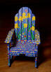 Adarondack chair painted with yellow flowers on a blue and green background as part of the Adirondack Chair Trail in Sandwich MA
