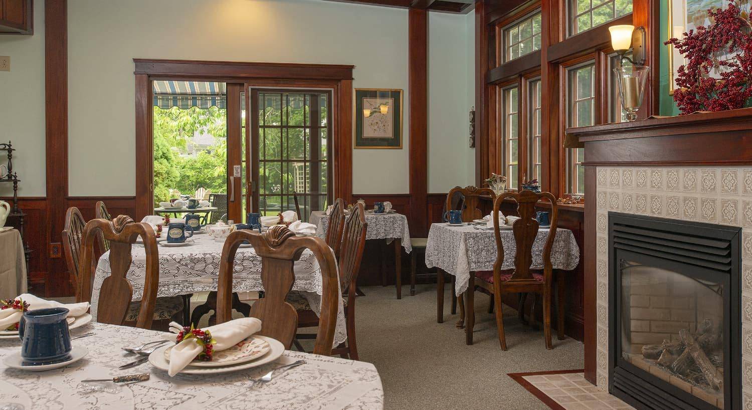 Large dining room with multiple wooden tables and chairs and a fireplace